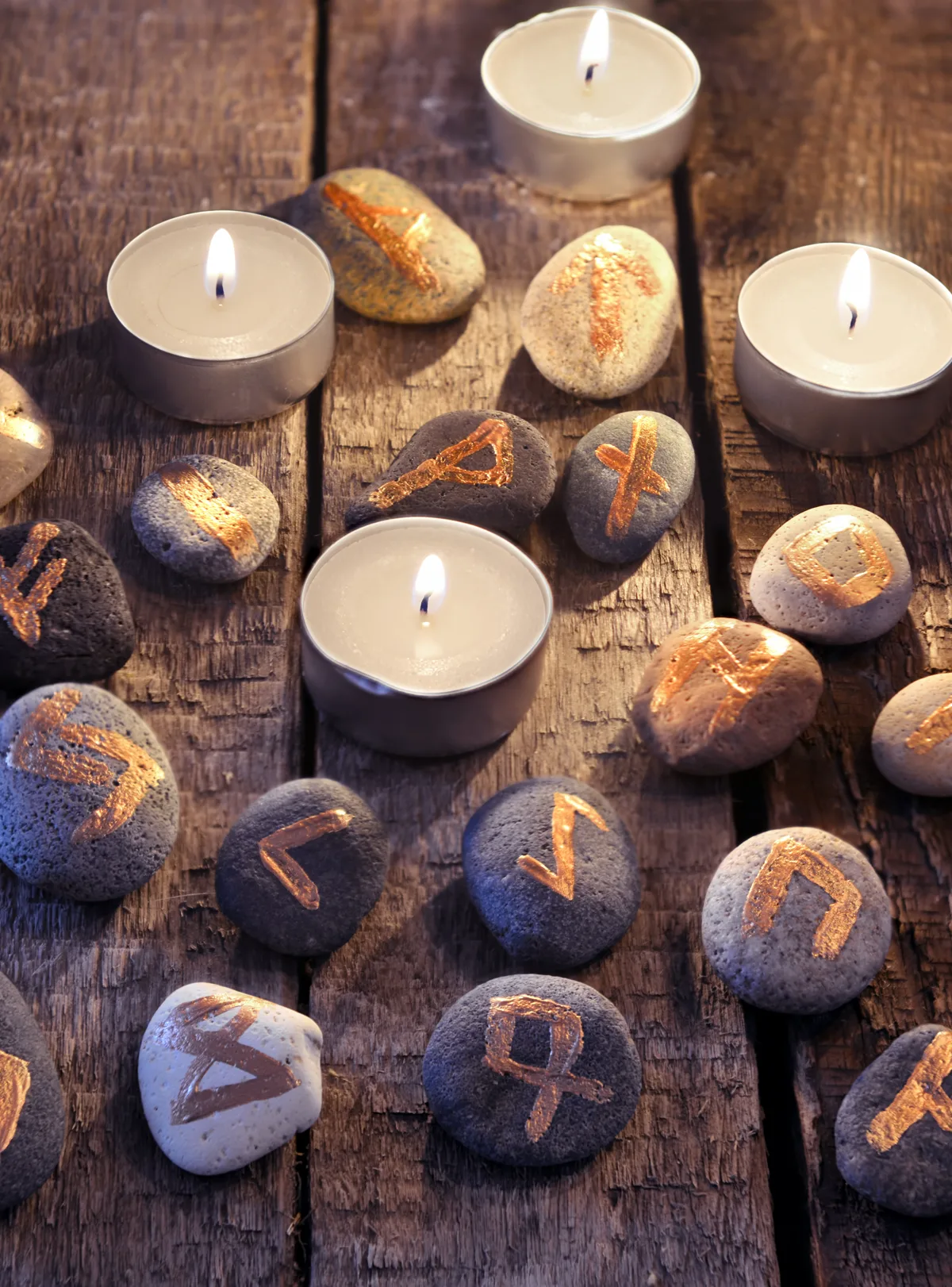 Piedras rúnicas doradas y velas encendidas — Oracle Gypsies