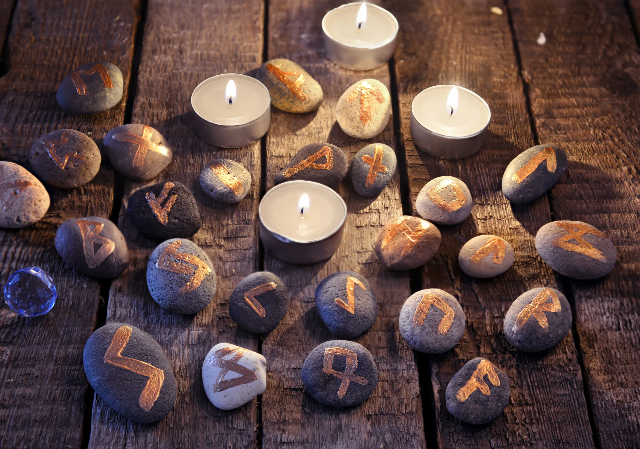 Piedras rúnicas doradas y velas encendidas — Oracle Gypsies